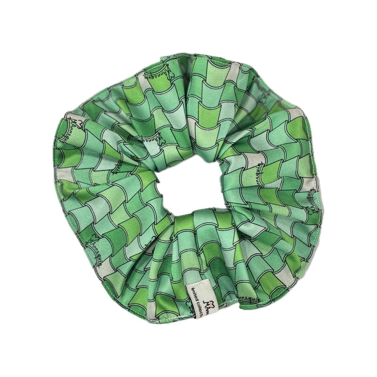 A green geometric patterned hair scrunchie.