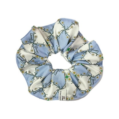 A blue and white floral pattern silky hair scrunchie.